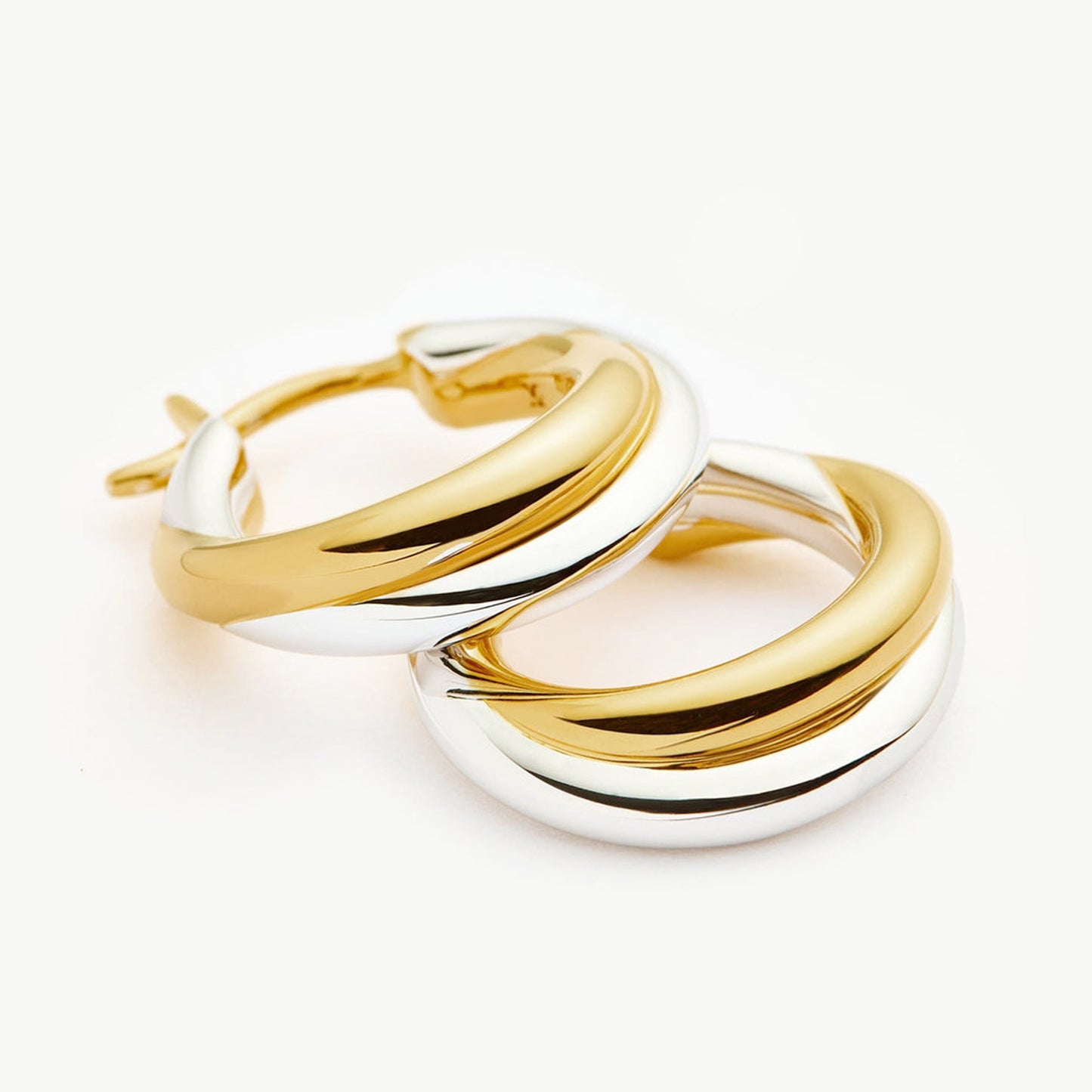Two-tone gold and silver Luna Twist Hoops styled in ear, showcasing sculptural minimal design 00100
