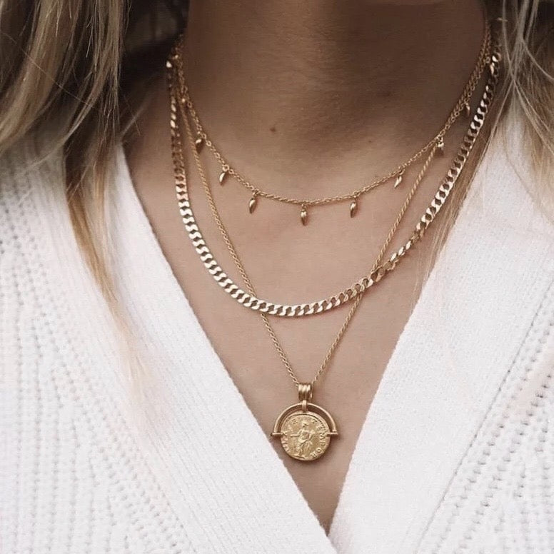 Gold coin pendant necklace featuring a medallion design, layered on model’s neck — Aurelia Medallion Necklace by MiaPromise.