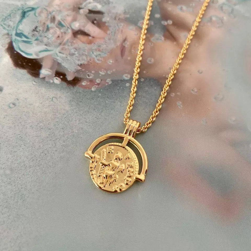 Gold coin pendant necklace featuring a medallion design, layered on model’s neck — Aurelia Medallion Necklace by MiaPromise.