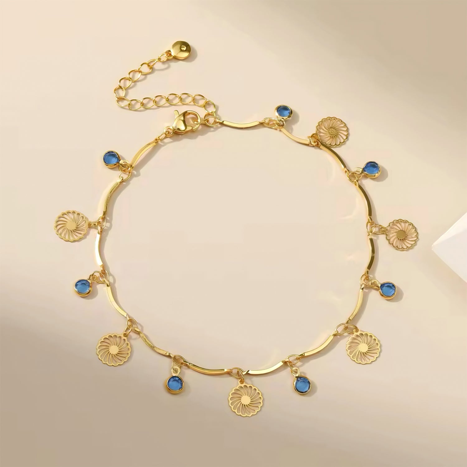 Blue Horizon Charm Anklet with ocean blue crystals and gold floral charm on wave chain 00050