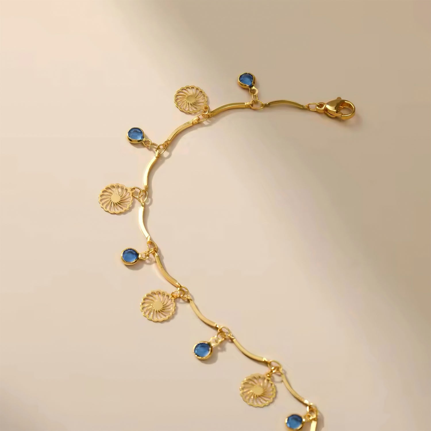 Blue Horizon Charm Anklet with ocean blue crystals and gold floral charm on wave chain 00053