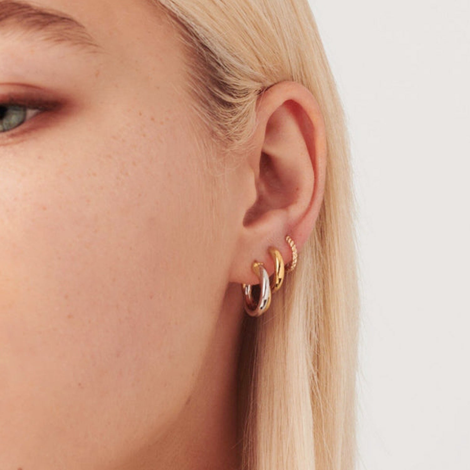 Two-tone gold and silver Luna Twist Hoops styled in ear, showcasing sculptural minimal design 00098