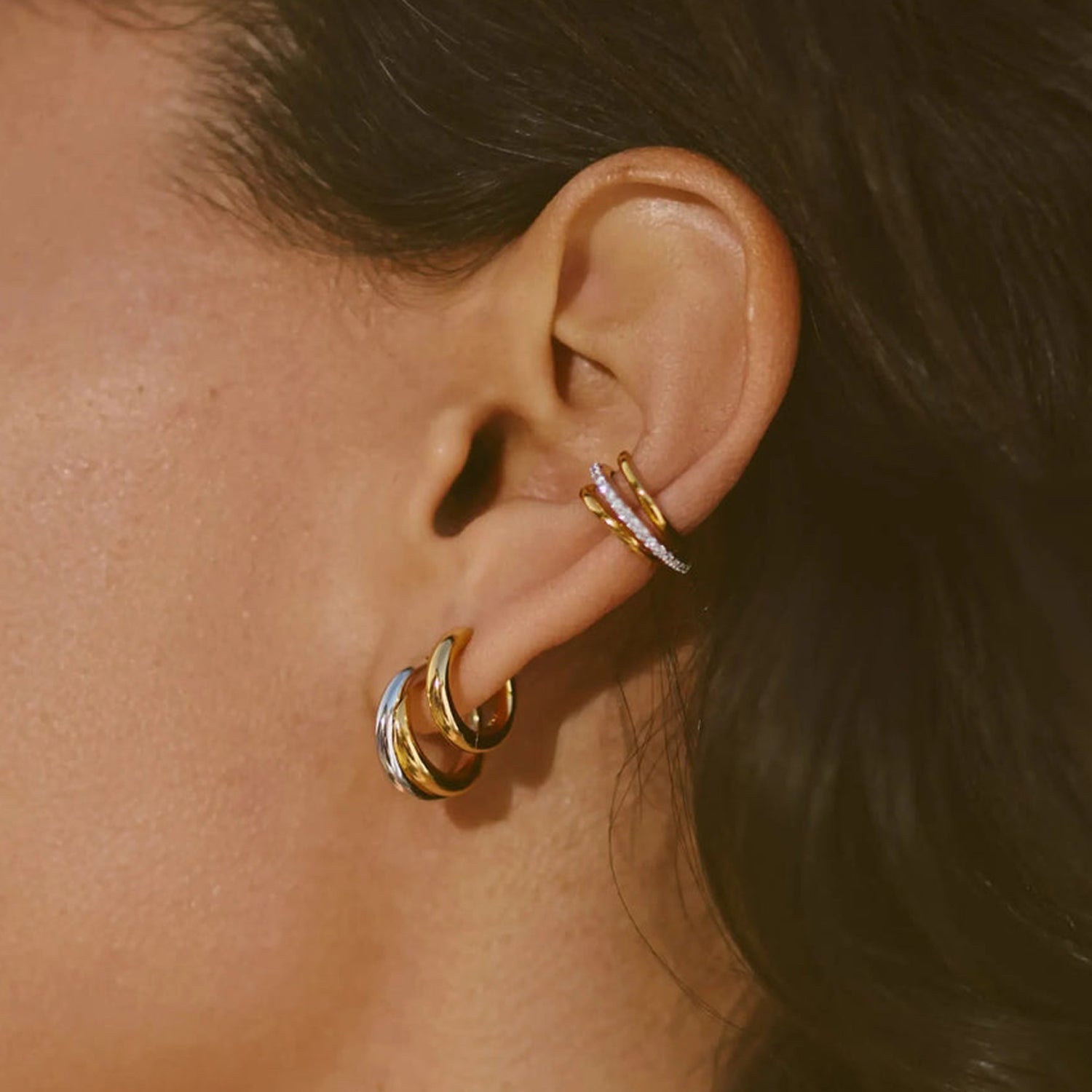 Two-tone gold and silver Luna Twist Hoops styled in ear, showcasing sculptural minimal design 00099