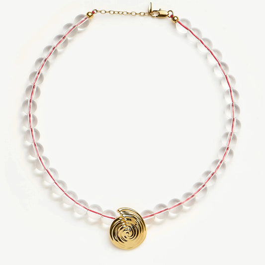 Onda Necklace with spiral wave gold pendant and clear round beads threaded by a red line — symbolizing movement and quiet energy, by MiaPromise.