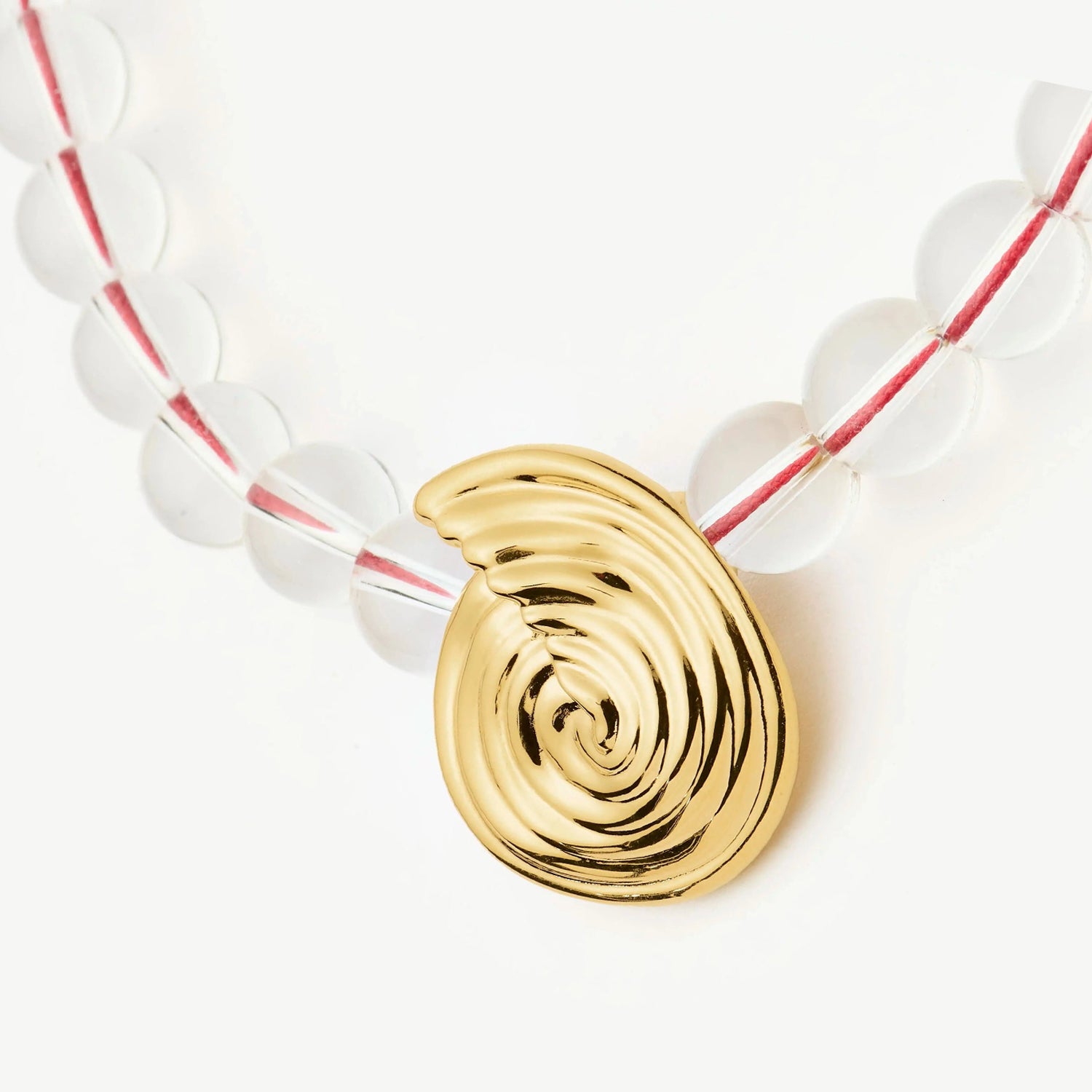 Onda Necklace with spiral wave gold pendant and clear round beads threaded by a red line — symbolizing movement and quiet energy, by MiaPromise.