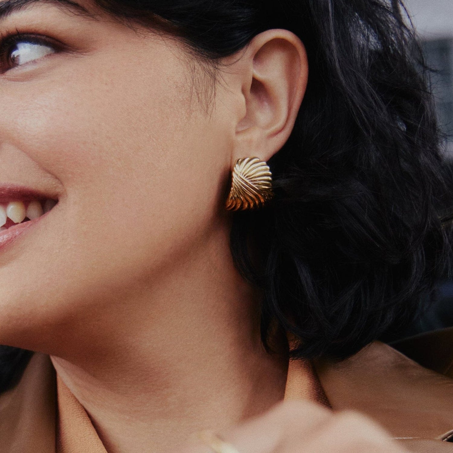 Sculptural gold feather earrings inspired by wind and movement, bold yet elegant with curved design — Zephyr by MiaPromise.
