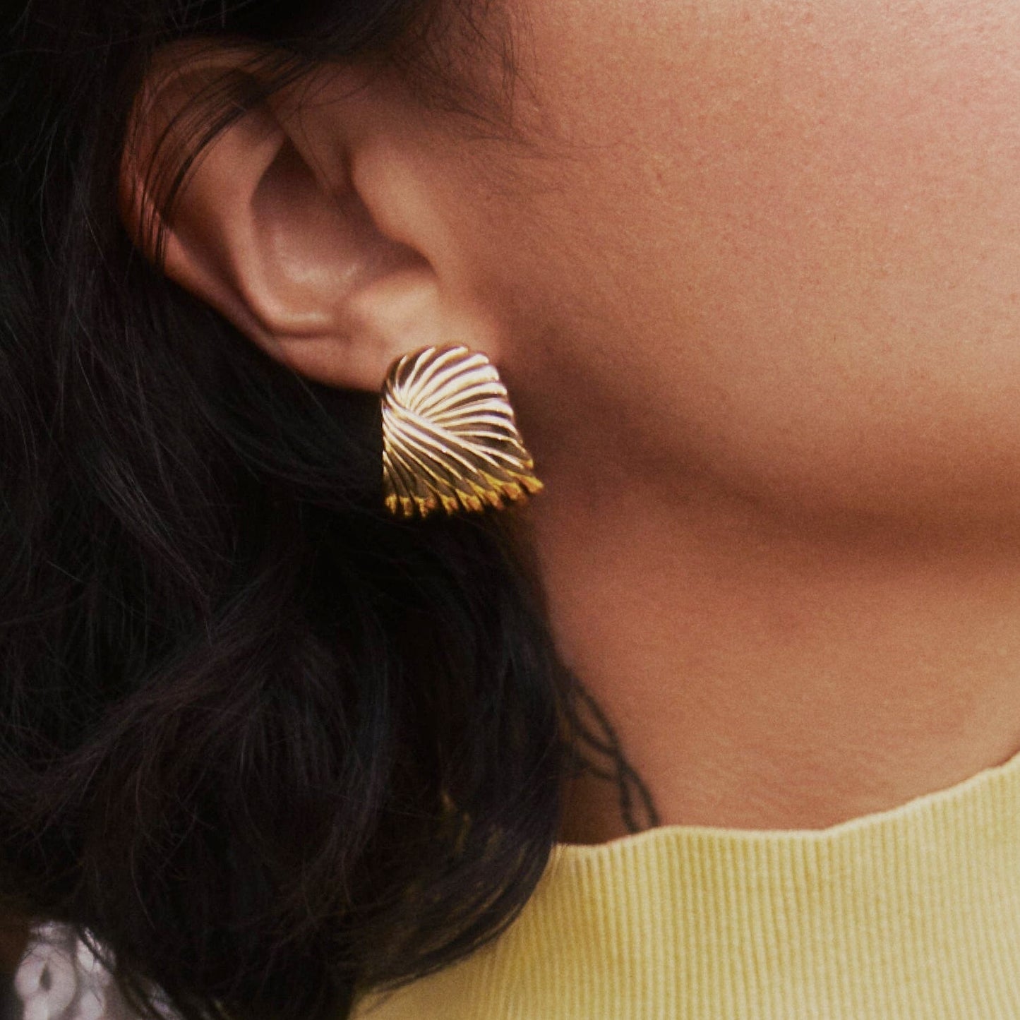 Sculptural gold feather earrings inspired by wind and movement, bold yet elegant with curved design — Zephyr by MiaPromise.